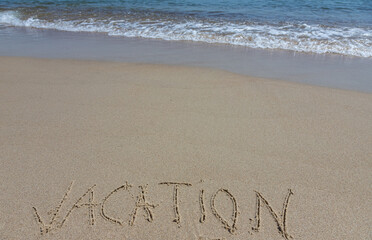 Handwritting inscription Vacation word on tropical sandy beach, travel concept card for holidays
