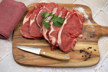 raw beef meat with spices and herbs on wooden cutting board