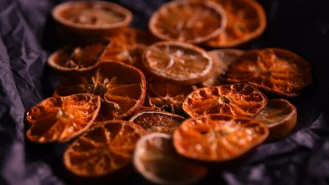 4k video with dehydrated food, dried oranges and lemons on dark background. Great texture of this dry citrus. Food and limonade ingredients.