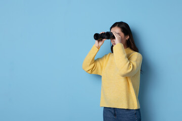 Asian woman looking through binoculars