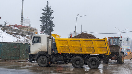 View of the construction site with snowy weather. Construction of a new bridge in winter in the city.