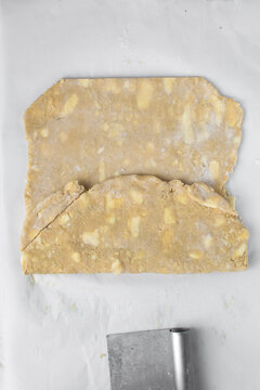 danish pastry dough being laminated, pastry dough with pieces of cold butter, process of laminating dough, letterfold pastry dough