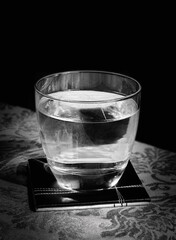 Glass of water on the table in a black background