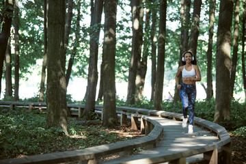 Young girl enjoying outdoors workout - young attractive and fit afro American woman running at countryside road in sport practice concept and healthy lifestyle