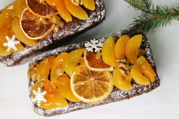 Traditional  Christmas stollen on white background. Dessert is decorated with dried fruits and candied fruits.