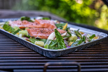 Selective focus on salmon and vegetables on charcoal barbecue