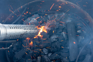 Lightning the charcoal in the barbecue with electric starter