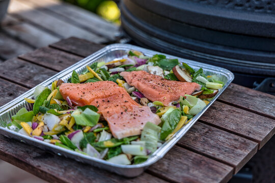 Barbecue plate with mixed vegetables and salmon ready to cook