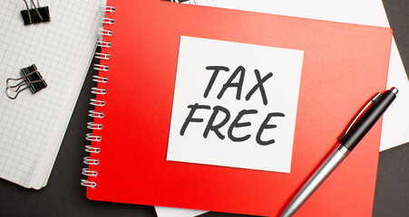 TAX FREE sign on sheet of paper on the red notepad with pen