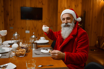 Portrait of happy smiling Santa drinking tea