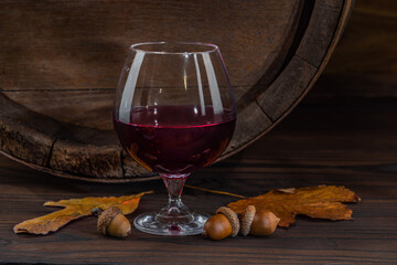 Wine glasses with tall stem. Old oak barrel in a dark wine cellar at the winery. Aging cellaring wine tasting