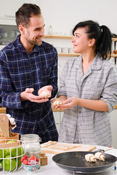 Picture of happy loving couple in pajamas, who cook together. Baking croissants. valentine's day