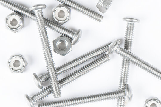 Metal bolts and nuts in a row background. Chromed screw bolts and nuts isolated. Steel bolts and nuts pattern. Set of Nuts and bolts. Tools for work.