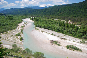 The course of clear river Isar in the bavarian alps surrounded by forests and mountains
