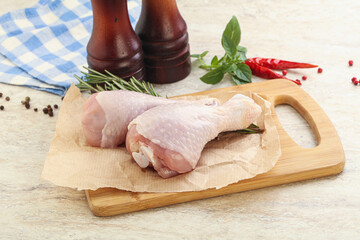 Raw chicken leg over board