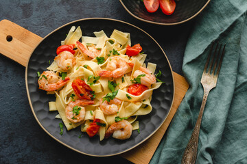Pasta with shrimp in a garlic sauce with butter, parsley and cherry tomato.