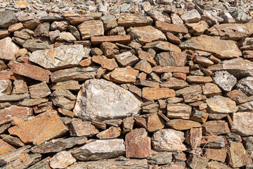 Fototapeta premium Beautiful texture of an old wall from orange stones with cracks
