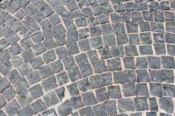 Fototapeta premium Beautiful texture of path of gray square stones with sand is in the park