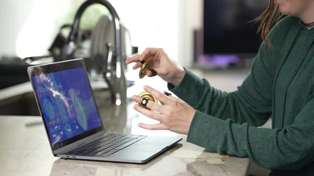 Woman takes remote lesson to learn finger cymbals online on a laptop. Remote learning concept.