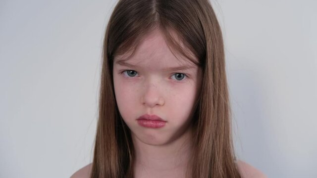 offended little girl looks at the camera. Negative emotions of the child.