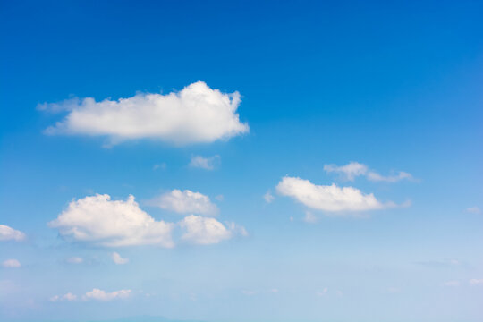 sky with fluffy clouds. white cumulus sparse cloudscape on a deep blue gradient of atmosphere. sunny summer weather. beautiful nature background. meteorology backdrop. fresh air. freedom concept