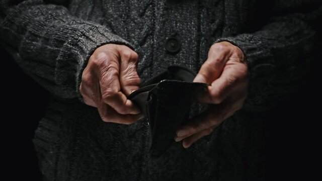 Empty wallet in senior hands, opens and empty, no money. Poverty in retirement concept