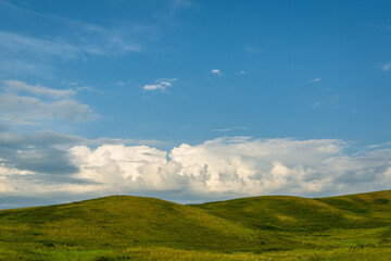 Fototapeta premium Green field and hills with blue sky.