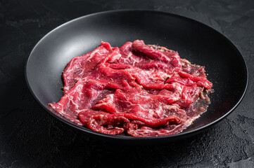 Marbled beef meat carpaccio. Black background. Top view