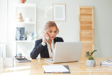 Young business woman working on laptop in office