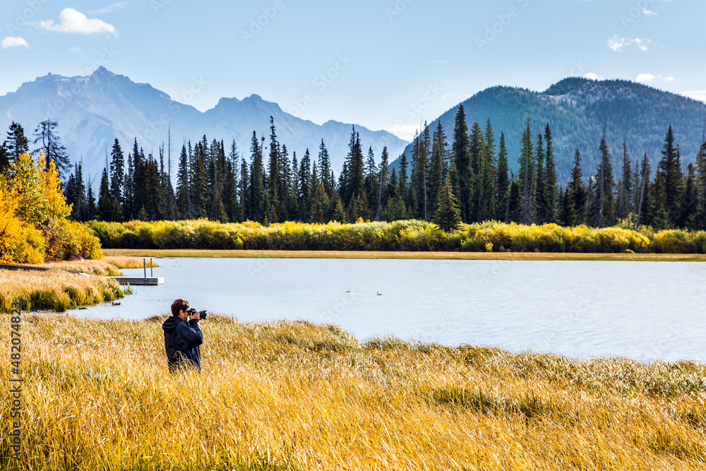 Wall mural woman photographing a lake