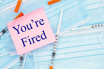 Youre Fired message with disposable face mask and needles with note