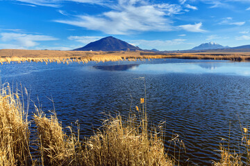 Nameless lake on the background of blue sky and mountains of Caucasian Mineral waters. The Bull and Beshtau mountains, the laccoliths of the North Caucasus. Winter landscape