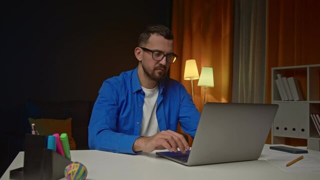  Handsom bearded man with laptop having video call at home