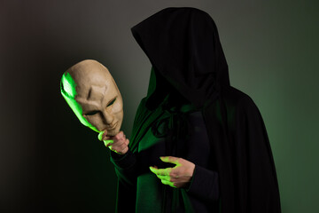 An anonymous villain, a hidden figure in a black cape with a hood. A mystical character with a...