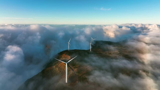 Green alternative wind energy. Renewable energy landscape. Wind turbines produce electricity in the mountains. Wind turbines hidden in the morning fog. Madeira, Portugal. Foggy mystic landscape.
