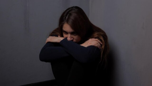 Depressed woman alone in a dark room