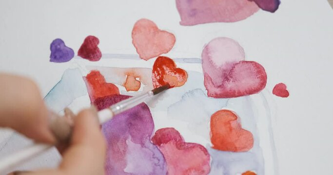 Drawing painting handmade Saint Valentine's card for celebrating St. Valentine Day. Crafting the gift for beloved - a postcard with colorful red and pink hearts