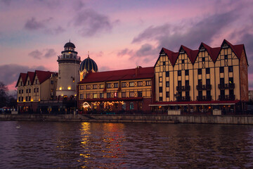 Obraz premium Fishing village in Kaliningrad at night. Stylization of ancient Europe, lighthouse, ancient houses.
