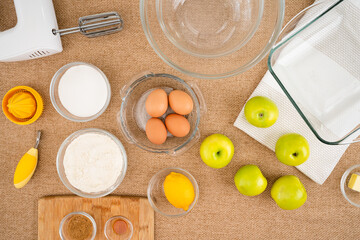 Apple cake with biscuit base recipe. Green apples, and ingredients for baking needs close up