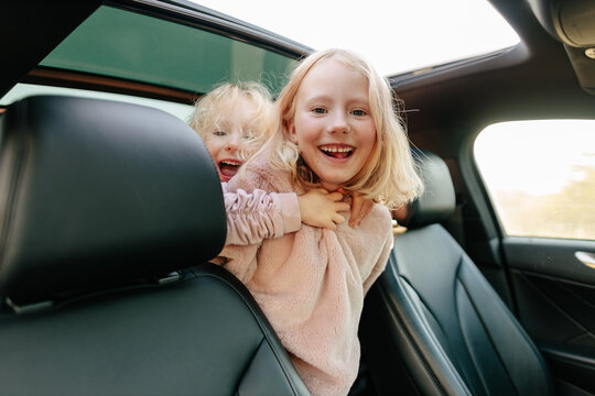 Positive sisters playing in car