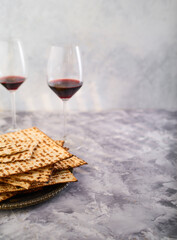 Easter composition on a gray marble background. Traditional Jewish bread matzah and two glasses of red wine. Jewish Passover, kosher food, Judaism, advertising, invitation. - 482086454