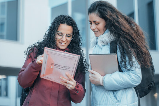 Chicas alumnas jovenes estudiando en el recreo de su universidad para realizar una tarea en clase