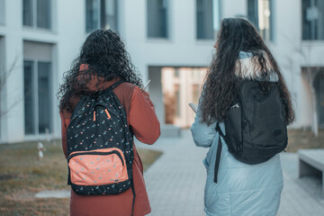 Muchachas amigas universitarias en el exterior del campus universitario estudiando en el recreo...
