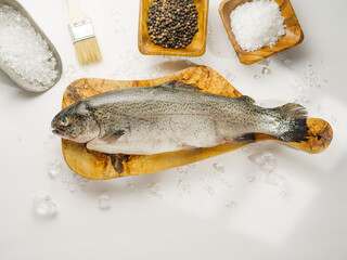 Fresh fish on a cutting board, salt, spices on a white background. Cooking fish dishes. Cookbook, cooking blog, recipes, home cooking, restaurant, supermarket.