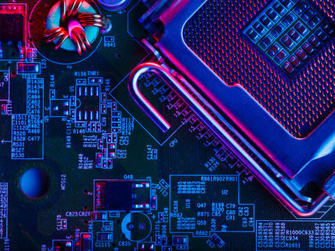 The desktop of the processor lies with the contacts up on the motherboard of a personal computer. macro photography. Neon lighting. Computer component, modern technology, engineering.