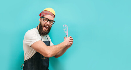 Profession charismatic chef cook holding bowl and whipping something with whisk. Copyspace for ad. Time to cook