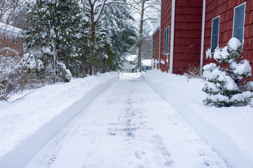 cleaned driveway by red suburban house after the snow storm