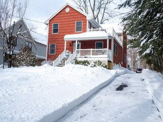 Red suburban house and driveway after the snow storm in February