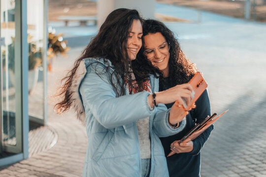 Chicas escolares adolescentes haci&eacute;ndose una foto de selfie en el descanso del recreo al terminar su tarea de la universidad para subirlo a sus redes sociales con entusiasmo