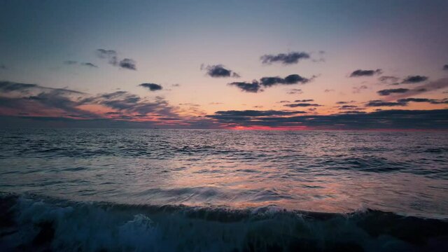 Drone Pulling Back Over Tide Coming In Over Beach At Sunset